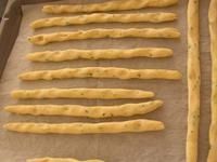 bread sticks are lined up on a baking sheet