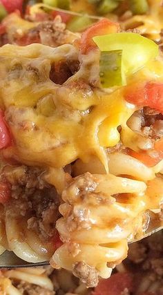 a spoon full of cheeseburger casserole with meat and vegetables on it