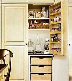 an open pantry door in a kitchen next to a chair