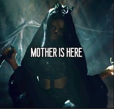 a woman dressed in black and holding a knife with the words mother is here on it