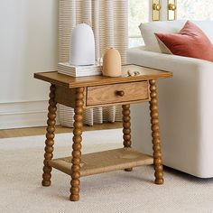 a small wooden table sitting in front of a white couch