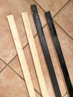 three pieces of wood sitting on top of a tile floor next to a knife blade