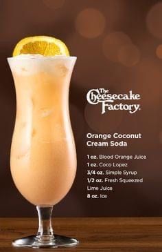 the orange coconut cream soda is served in a tall glass with an orange slice on top