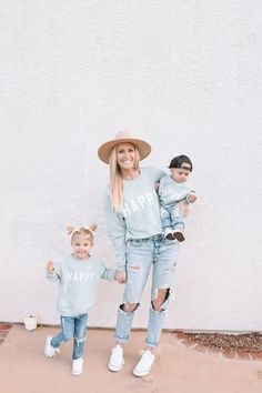 a mother and her two children wearing matching happy sweaters, jeans and hats with the words happy on them