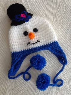 a crocheted snowman hat with pom - poms