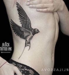 a woman's stomach with a bird tattoo on her side and the words lassova written in russian