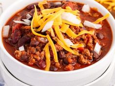 a white bowl filled with chili and cheese