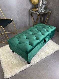 a green bench sitting on top of a white rug