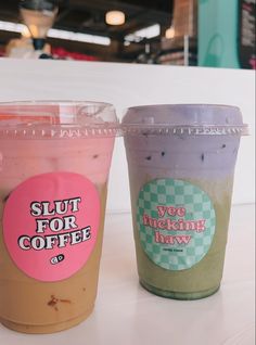 two cups of coffee sitting next to each other on a white counter top in a restaurant