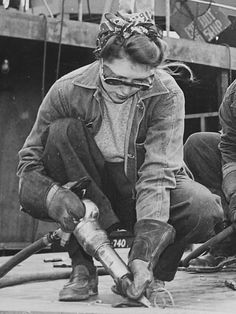 two men working with tools on the deck of a ship in black and white photo