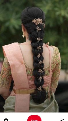 the back of a woman's head with long black hair and braid in it