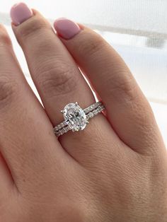 a woman's hand with two engagement rings on it