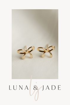 Experience the magic of Luna & Jade's Bow Studs – a stunning combination of elegance and fun. These versatile earrings make the perfect gift idea for any occasion, offering a touch of whimsy and charm to any outfit. Get ready to make an impression with these irresistible accessories. Shop Now! Gold Dainty Bow Earrings, Gold Dainty Earrings With Bow, Dainty Gold Earrings With Bow, Dainty Gold Bow Earrings, Gold Earrings With Bow Tie Detail For Gift, Gold Bow Tie Earrings For Gift, Gold Butterfly Knot Earrings For Gift, Gold Earrings With Butterfly Knot For Gift, Gold Butterfly Knot Earrings As A Gift