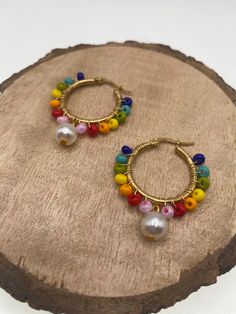 -Colorful hoop earrings that will spice up your looks! -Made with wire, Czech beads and pearls. -These Earrings are simple and yet so fun!  -Whether you're going for a casual or a dressy look, these earrings will add the perfect final touch to all your looks! CARE INSTRUCTIONS TIPS: -Avoid strong chemicals and water to keep them looking like new for much longer -Store away from other jewelry to avoid tangling or scratches -Clean with a soft, dry cloth SHIPPING: -  We are dedicated to ship your orders as soon as a possible.  -Most orders will be shipped out within the same day the order was placed.  -  Feel free to contact us if you need to rush your order, we are happy to accommodate.  -Free shipping on orders over $35 -Feel free to contact us for more details.   ADDITIONAL INFO: -An Origi Multicolor Wire Wrapped Dangle Beaded Earrings, Colorful Dangle Hoop Earrings With Ear Wire, Colorful Dangle Hoop Earrings, Multicolor Wire Wrapped Beaded Earrings, Multicolor Wire Wrapped Earrings With Round Beads, Bohemian Rainbow Wire Wrapped Earrings, Multicolor Wire-wrapped Beaded Earrings For Gift, Multicolor Wire Wrapped Beaded Earrings For Gift, Multicolor Wire Wrapped Hoop Earrings For Gifts