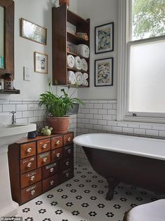 a bath room with a tub a sink and a mirror on the wall next to a window