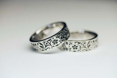 two wedding rings sitting next to each other