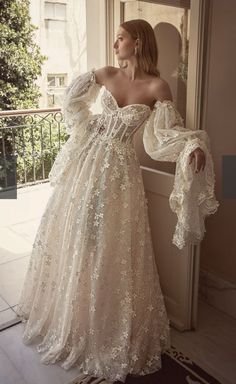 a woman in a wedding dress leaning against a wall