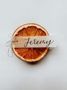 an orange cut in half sitting on top of a table with a paper sign that reads fereny