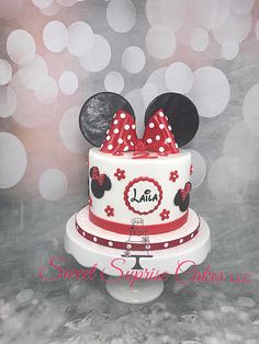 a minnie mouse cake is decorated with red and white polka dots