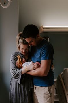 a man and woman holding a baby in their arms