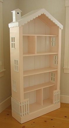 the doll house is made out of wood and has white trimmings on it