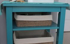 a blue shelf with baskets on top of it next to a white toilet paper dispenser