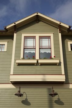 a green house with two windows on the side