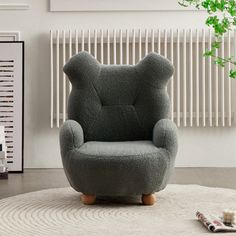 a grey teddy bear chair sitting on top of a rug in front of a radiator