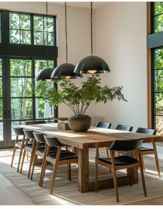 a dining room table with black chairs and a potted plant on top of it