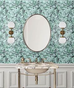 a white sink sitting under a round mirror next to a wall mounted faucet