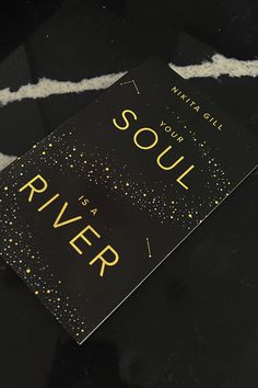 a black book with gold foil lettering on the cover and some white streamers around it