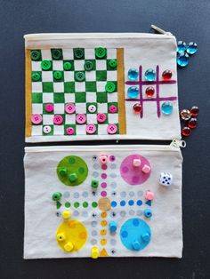 two zippered pouches with buttons and sewing needles on them, one is made to look like a board game