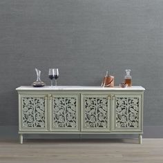 an ornate sideboard with wine glasses on top