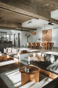 a living room filled with furniture next to a dining room table and bar in the background