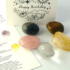 three different colored rocks next to a greeting card