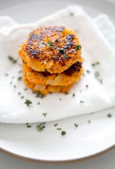 two crab cakes sitting on top of a white plate