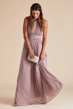 a woman in a long dress holding a purse