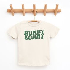 Looking for a cute tee for your kids? We have the perfect Hunny Bunny Wavy graphic tee addition to their closet! Also available in toddler tees. Family Matching Green T-shirt With Graphic Print, Green Family Matching T-shirt With Graphic Print, Graphic Tee Trends, Playful Slogan T-shirt For Spring, Funny Cartoon Print T-shirt For Spring, Playful Spring T-shirt With Text Print, Happy Bunny Shirt, Baby Girl Graphic Tee, Casual Crew Neck T-shirt With Bunny Design