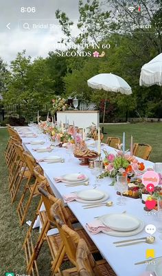 a long table set up with plates and umbrellas for an outdoor dinner party in the backyard