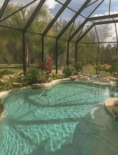 an indoor swimming pool surrounded by glass walls