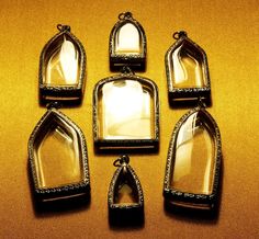 six pieces of glass with silver trim on a yellow surface, including one in the middle