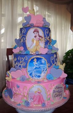 a three tiered cake decorated with princesses and hearts