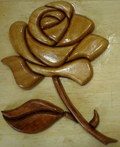 a wooden carving of a flower on a table