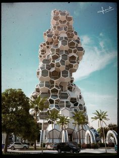 a very tall building with lots of cubes on it's side and palm trees in the foreground