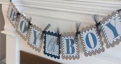 a birthday banner with the word boy on it hanging from a mantle in front of a fireplace