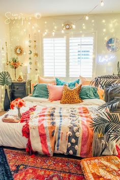 a bed with colorful blankets and pillows in a room filled with lights, rugs and decor