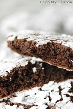 chocolate crinkle cookies with powdered sugar are stacked on top of each other