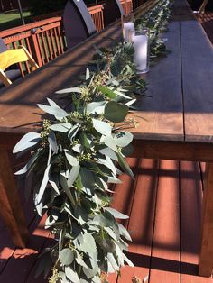 the table is set with eucalyptus leaves and candles