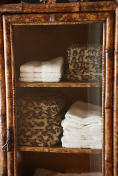 towels are stacked on top of each other in a wooden cabinet