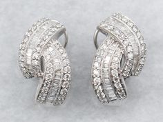 Crafted in the diamond-studded style of the Hollywood Renaissance, these vintage earrings are ready for the red carpet! The style is Retro, but the earrings themselves feature all of the best parts of modern design: The post omega backs are comfortable and secure on the ear, and the setting of the diamonds is magical! Metal: 14K White GoldGem: 109 Diamonds totaling 2.58 Carats, SI-I in Clarity, G-I in ColorGem Measurements: 1.6 mm, RoundMeasurements: 13 x 23 mmMarks: "14K" Stamped on the findings Earrings White Gold, White Gold Diamond Earrings, Earrings Diamond, Gold Diamond Earrings, Baguette Cut Diamond, Colored Gems, Earrings White, Diamond Drop Earrings, Channel Set